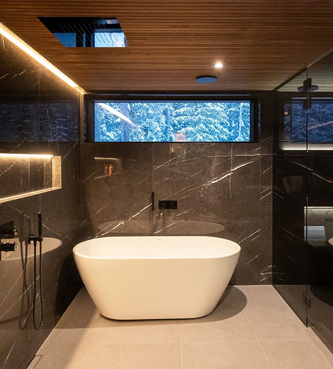 Tumma kylpyhuone valaistu led nauhalla ja alasvalolla